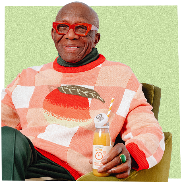Mann trägt einen großen Strickpullover und trinkt einen innocent Smoothie
